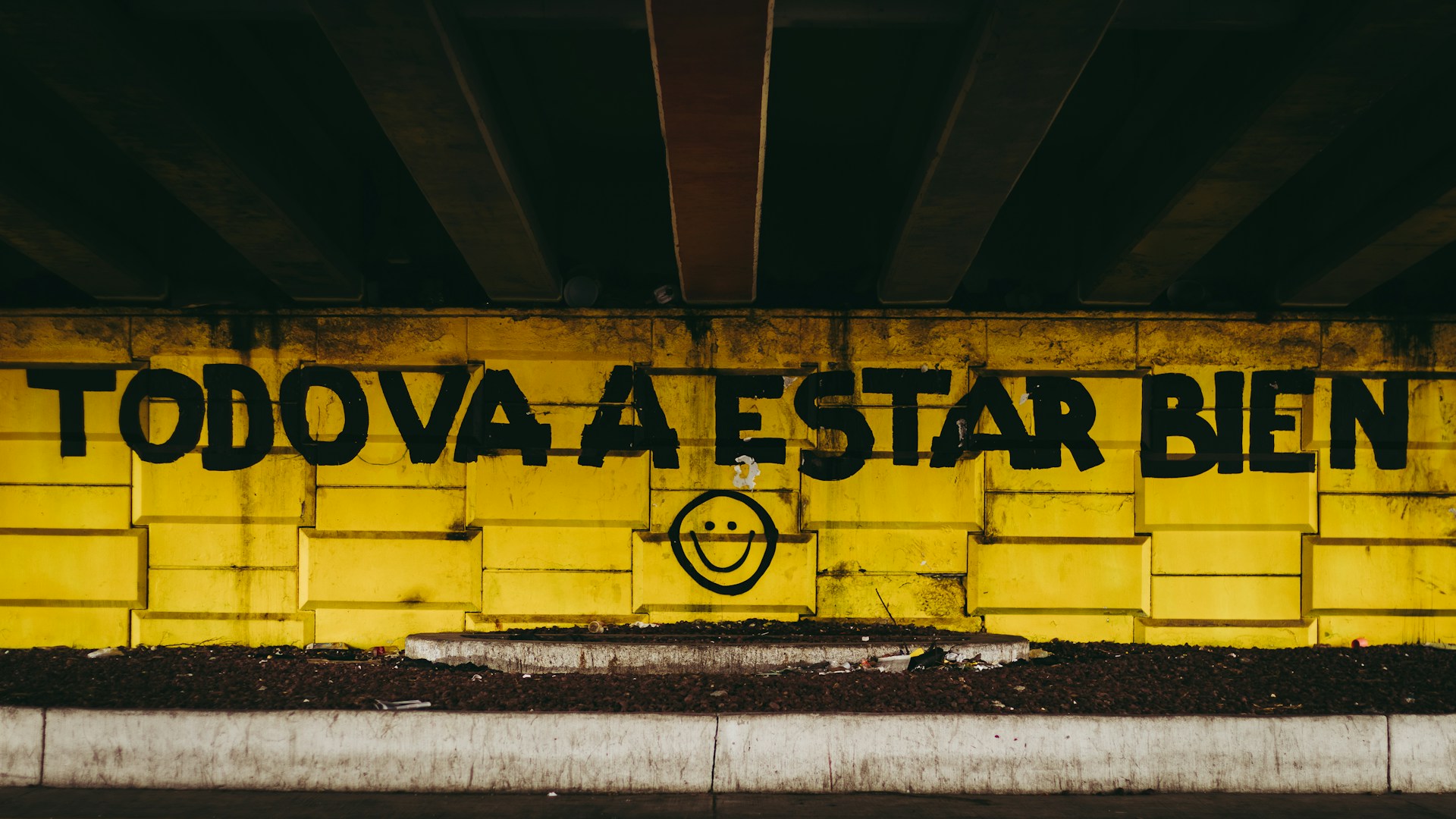 A text written on a wall saying 'todo va a estar bien' and a smiley face