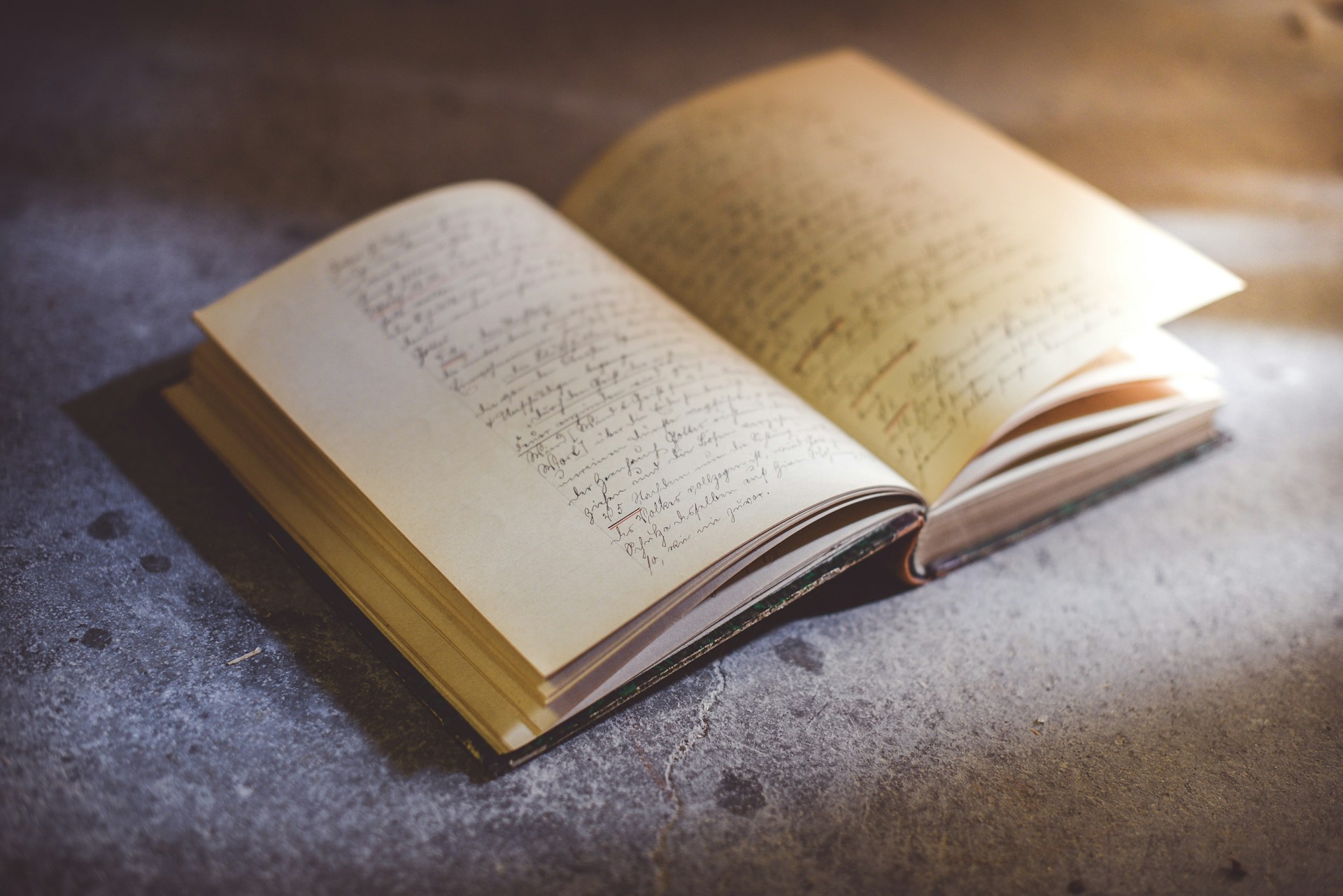An open book resting on a grey surface
